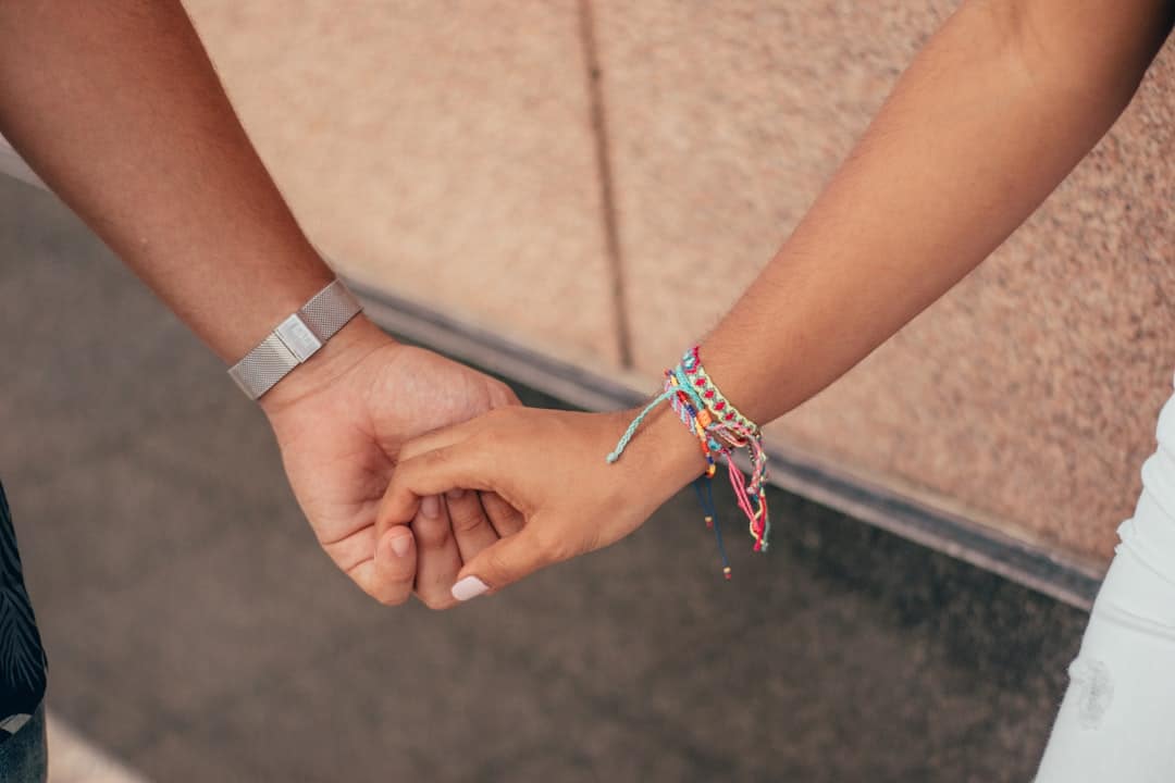 A minimalist photo showing two hands pulling in opposite directions on a single house key against a plain background, illustrating a dispute over home ownership.